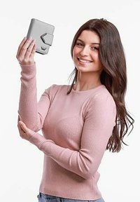 Šedá peněženka s texturovaným povrchem,  disponující klopovým uzávěrem a logem jako akcentem. Držena osobou, která má na sobě růžový žebrovaný svetr.