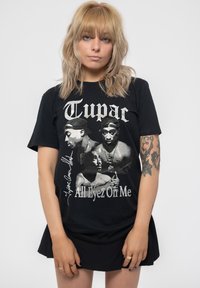 Black cotton t-shirt featuring a graphic print of two figures and the text "Tupac All Eyez On Me" in silver, with a crew neck and short sleeves.