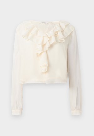 Valge pika varrukaga blouse, millel on V-kaelus ja volangidega esidetail. Valmistatud kergest kangast, omab lühendatud disaini ja pehmet tekstuuri.