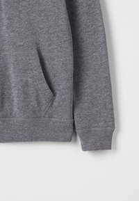 Grijze katoenen sweatshirt met een voorzak, ribgebreide manchetten en zoom. De stof heeft een zachte textuur en een uniforme heatherpatroon.