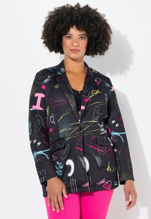 Blazer noir avec des motifs de style graffiti colorés en rose, bleu et jaune. Il présente une fermeture à un bouton et deux poches avant.