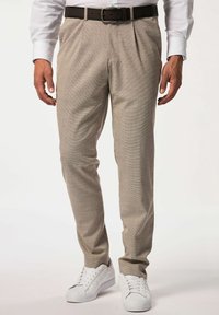 Helle beige, plissierte Hose mit strukturiertem Gewebe, kombiniert mit einem braunen Gürtel und weißen Sportschuhen. Eignet sich für legere Outfits.