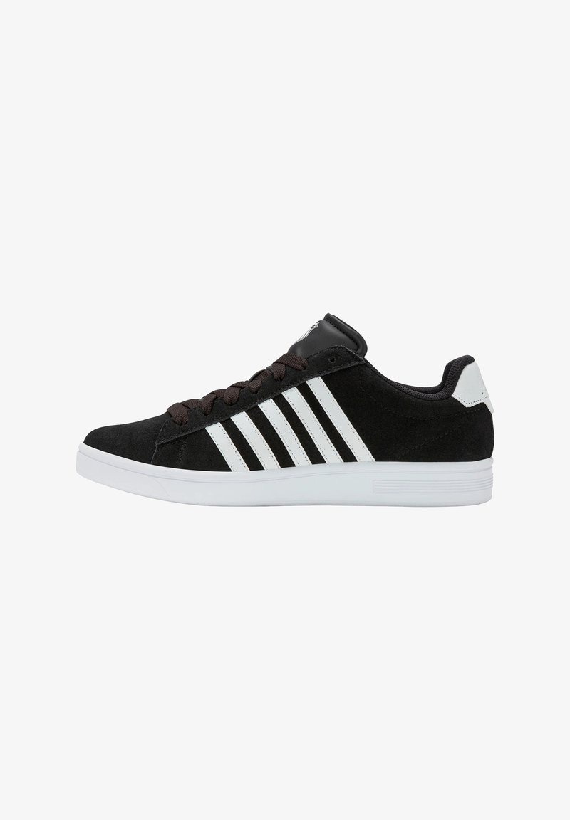 Adidași negri din suede cu un design cu trei dungi albe, șireturi maro și o talpă din cauciuc albă. Siluetă joasă cu guler căptușit.