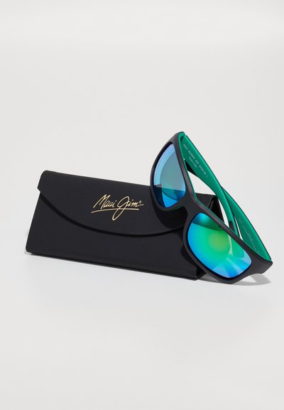 Musta Maui Jim -aurinkolasit, joissa on suuret vihreänsiniset peililinssit, varustettuna mustalla suojakotelolla, jossa on kullanvärinen brändilogo.