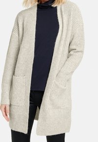 Ljusgrå stickad kofta med lös passform, öppen framsida och två framfickor. Texturerad tyg med ribbdetaljer.