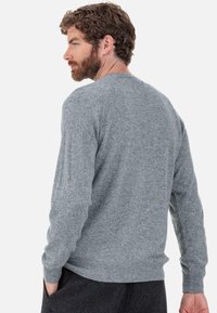 Grauer, gestrickter Pullover mit langen Ärmeln, gerippten Bündchen und Saum. Weiche Textur und rundhalsausschnitt. Von hinten gesehen, leicht vom Körper abgehoben gehalten.