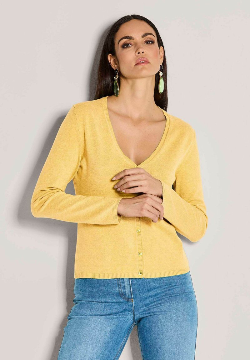 Gelbe Strickjacke mit tiefem V-Ausschnitt, langen Ärmeln und einer Knopfleiste mit hellgrünen Knöpfen; weicher Stoff und taillierte Passform.