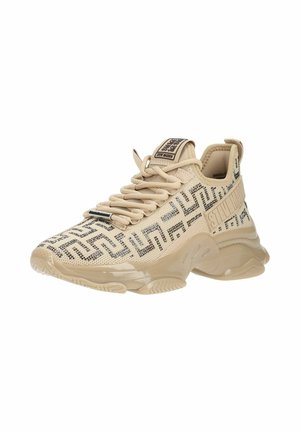 Zapatilla beige de punto con patrón geométrico negro, suela acolchada, cordones frontales y lengüeta y talón con marca.