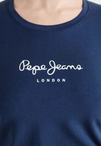 Navyblauwe t-shirt van zacht katoenmateriaal, met een witte cursieve "Pepe Jeans" logo en de tekst "LONDON" in het midden. Korte mouwen, ronde hals.