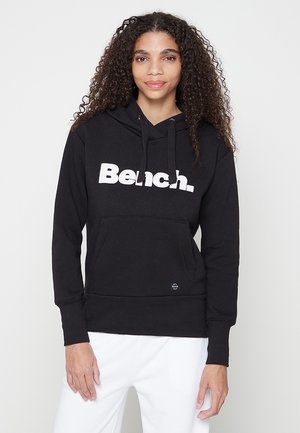 Schwarzer Kapuzenpullover mit großem weißen "Bench."-Logo, versehen mit einer vorderen Tasche und einer Zugkordelkapuze. Hergestellt aus weichem, strukturiertem Stoff.