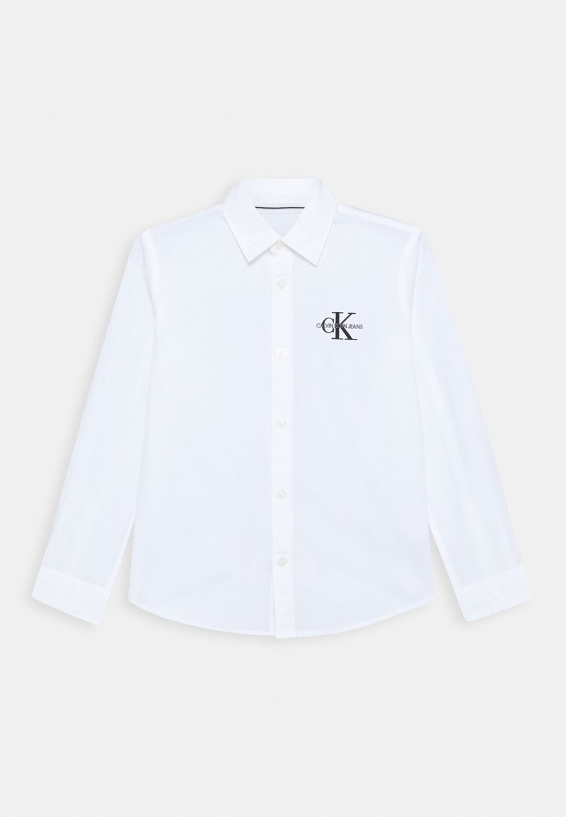 Biała koszula z długim rękawem i kołnierzykiem, z czarnym logo na lewej stronie klatki piersiowej. Wykonana z gładkiej tkaniny, zapinana na guziki z przodu.