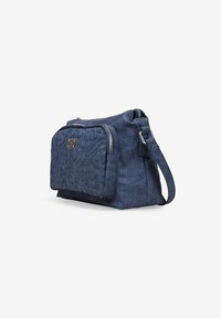 Bolso cruzado de mezclilla azul con un bolsillo frontal bordado con flores, herrajes plateados, cierre con cremallera y una correa ajustable y desmontable.