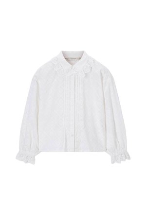 Chemise blanche à manches longues boutonnée, avec un col et des poignets en dentelle ajourée, présentant un motif subtil de diamants et des plis verticaux à l'avant.