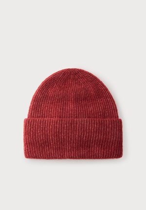 Bonnet côtelé tricoté rouge avec revers plié, présenté à plat sur un fond gris clair.