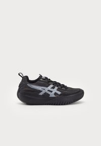 Black athletic shoe with a textured upper, featuring silver accents and a thick rubber sole. Designed with a lace-up closure and pull tab.