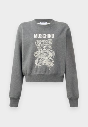 Šedá skrátená mikina s grafickým dizajnom medveďa v bielej farbe a s textom "MOSCHINO" nad ním. Mäkká textúra a rebrované manžety na rukávoch.