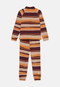 Completo di maglia a maniche lunghe e pantaloni con texture a coste, caratterizzato da strisce orizzontali in tonalità di arancione, beige e rosso scuro su uno sfondo bianco.