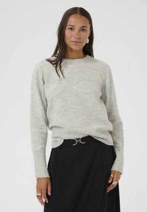 Light gray knit sweater with a round neckline and ribbed cuffs, paired with black trousers featuring a metallic belt accent. Smooth texture.