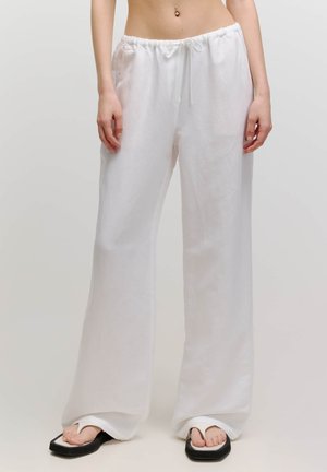 Weiße Leinen-Hosen mit weitem Bein, elastischem Bund und verstellbarem Kordelzug. Weiche Textur, fließendes Design und lockere Passform.