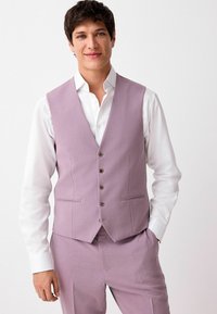 Lavendel Weste aus strukturiertem Stoff mit glatter Oberfläche, ausgestattet mit sechs Knöpfen, Reverskragen und Seitentaschen. Kombiniert mit einem weißen Hemd.