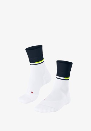 White socks with a navy ribbed cuff, featuring black and neon yellow stripes. Bottom shows a red logo on one sock.