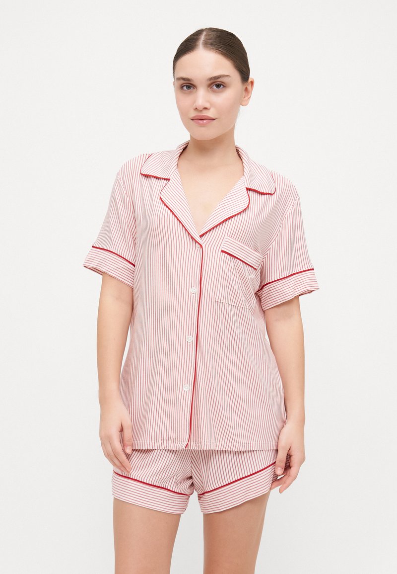 Striped cotton sleepwear set featuring a button-up short sleeve top with a pocket and matching shorts, in red and white colors.