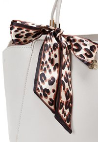 Bolso tote de cuero blanco con una bufanda de seda con estampado de leopardo beige atada al asa. Los detalles en dorado realzan el diseño.