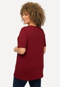 Bordeaux shirt met korte mouwen en een ronde halslijn, ontspannen pasvorm en een gladde katoenen stof; heeft een zoom die onder de taille reikt.