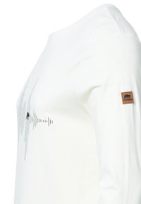 Weißes Langarm-T-Shirt mit einem grafischen Design, das Schallwellenmuster und die Silhouette eines Bären zeigt. Braunem Lederetikett am Ärmel.