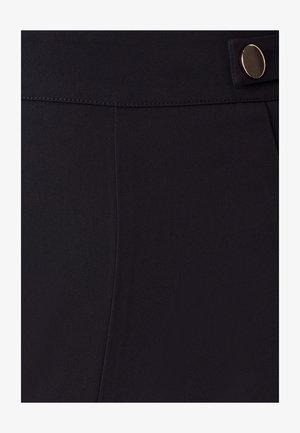 Melni bikses ar gludu tekstūru, pielāgotu dizainu, redzamām šuvēm un zelta toņa pogu aksesuāru pie jostas.