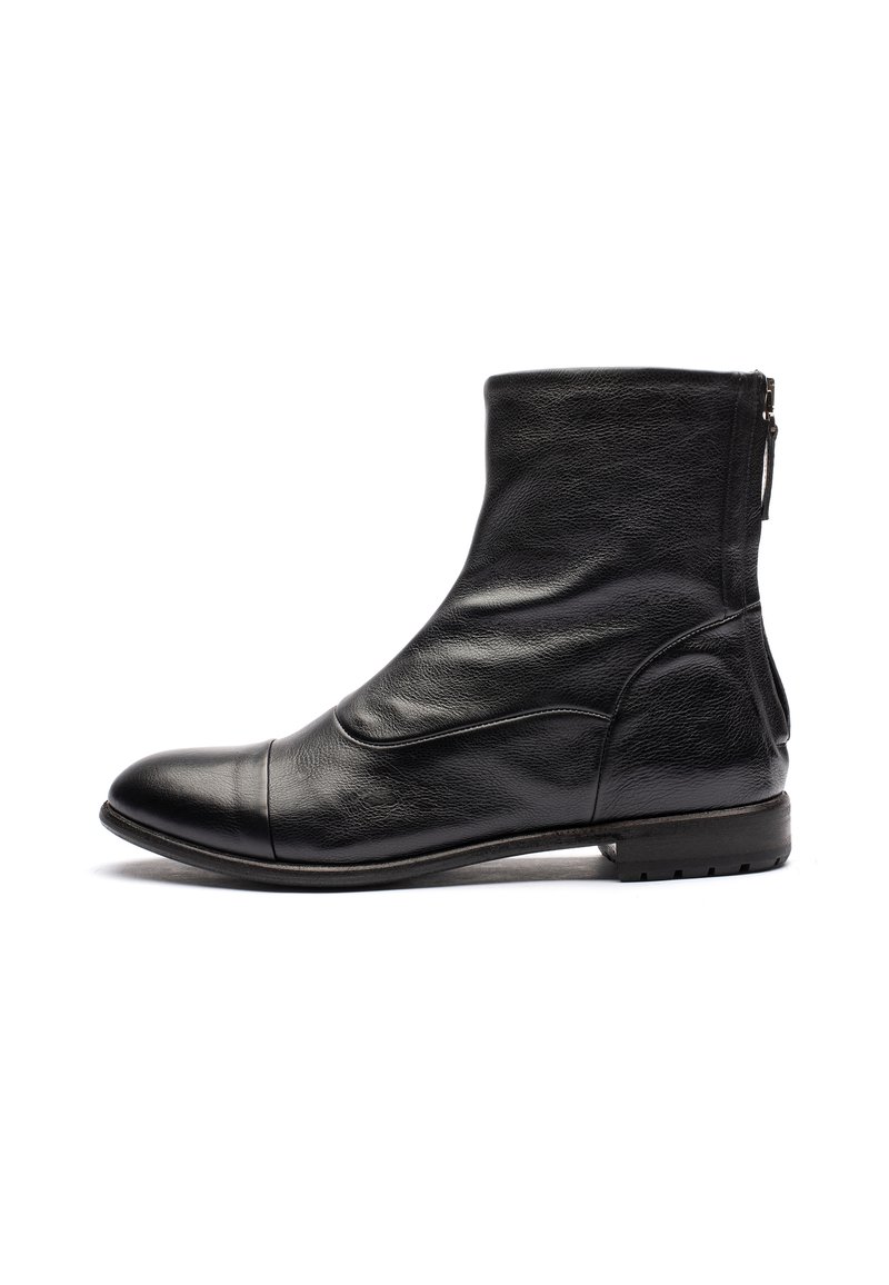 Stivaletto in pelle nera con una texture liscia, punta arrotondata, dettagli di cucitura delicati e chiusura con zip sul retro. Suola piatta.