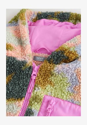 Multicolore bolletjesjasje met roze lining, roze ritsen en een "NEXT" kledinglabel in de kraag.