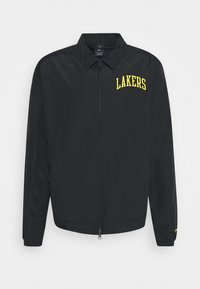 Schwarze Zip-Jacke mit umklappbarem Kragen, auf der linken Brust mit "LAKERS" in fettem gelben Text und elastischen Bündchen. Glatte Textur.