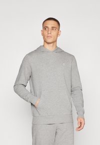 Grå sweatshirt lavet af blødt stof, med en frontlomme, ribbet manchetter og en let V-udskæring. Indeholder et lille logo på brystet.