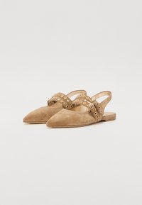 Scarpe slingback in suede beige con punta affusolata e due cinturini decorativi con accenti metallici circolari. Suola piatta per un maggiore comfort.