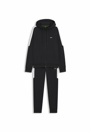 Schwarzer Kapuzenpullover mit Frontreißverschluss, Kordelzug und Logo, kombiniert mit passenden schwarzen Jogginghosen mit seitlichen Taschen und kontrastierenden Akzenten.