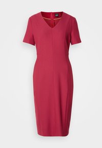 Robe rouge ajustée longueur genoux à manches courtes avec décolleté en V et fermeture éclair visible dans le dos sur fond blanc uni.