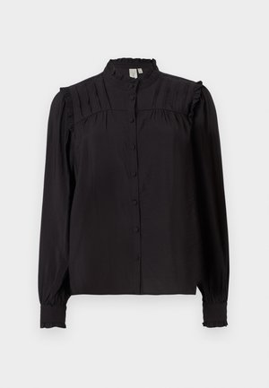 Juoda ilgomis rankovėmis bluzonė su aukštu apykakle, priekiniais mygtukais, raukšlėta apdaila ir volanų akcentais pečiuose ir rankogaliuose. Šilkinis paviršius.