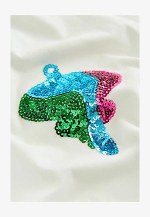 Un tessuto bianco presenta un vivace design di paillettes nei colori verde, blu e rosa, modellato a forma di farfalla con una superficie lucida e testurizzata.