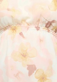 Miękka tkanina z elastycznym pasem, zdobiona pastelowym kwiatowym wzorem w odcieniach żółci, różu i jasnobrązu.