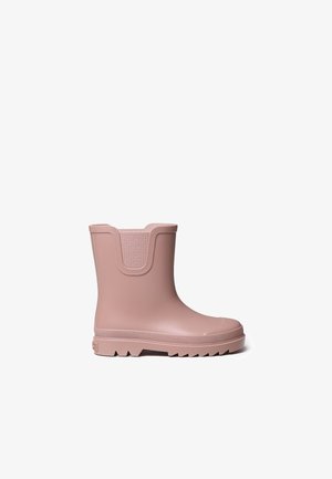 Botte de cheville en caoutchouc rose avec un accent en tissu texturé en haut, présentant une semelle crantée pour l'adhérence et un design à bout rond.