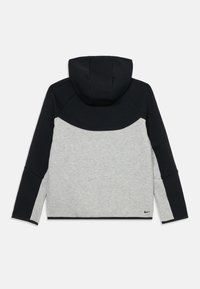 Hooded sweatshirt with a black upper section and light gray lower section. Features a textured fabric and a Nike logo at the hem.
