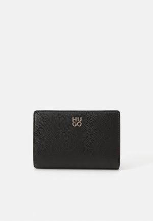 Cartera de cuero negro con una superficie texturizada, que presenta un logotipo metálico "HUGO" en la parte frontal. Forma rectangular compacta con un diseño plegable.