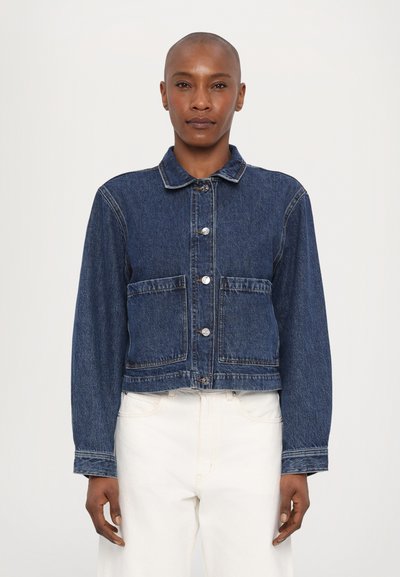 Veste en denim courte de couleur bleu foncé avec col classique, fermeture à boutons à l'avant, deux grandes poches et accents de boutons sur les manches.