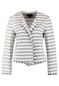 Blazer a righe bianche e blu navy con colletto, chiusura a un bottone e orlo sfrangiato. Realizzato in tessuto intrecciato con superficie texture.