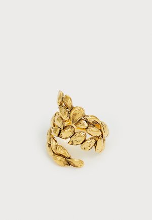 Anillo en tono dorado con formas de hojas superpuestas y texturizadas que forman un diseño de banda abierta y ajustable sobre un fondo blanco.