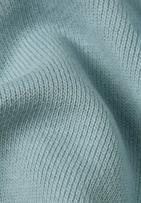 Tejido de punto azul claro con un patrón texturizado fino. El material parece suave y tiene un sutil brillo, mostrando puntadas ajustadas.