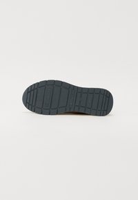 Semelle de chaussure en caoutchouc avec une surface texturée bleue. Présente un motif de semelle pour une adhérence et une durabilité accrues.