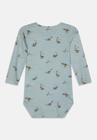 Langermet body i lyseblått stoff, med ulike dinosaurtrykk i grønt, brunt og beige, samt tekstetiketter. Myk, glatt tekstur.
