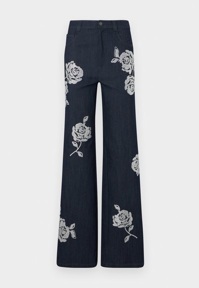 Wijdie denimbroeken in donkerblauw met witte geborduurde rozenpatronen. Voorzien van een knoopsluiting en een traditioneel zakontwerp.